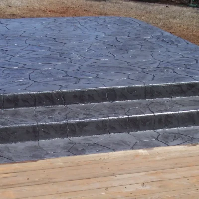 Stamped concrete patio with steps down to decking 