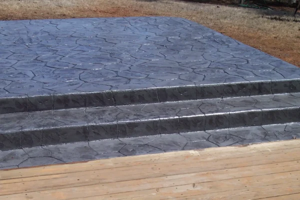 Stamped concrete patio with steps down to decking 