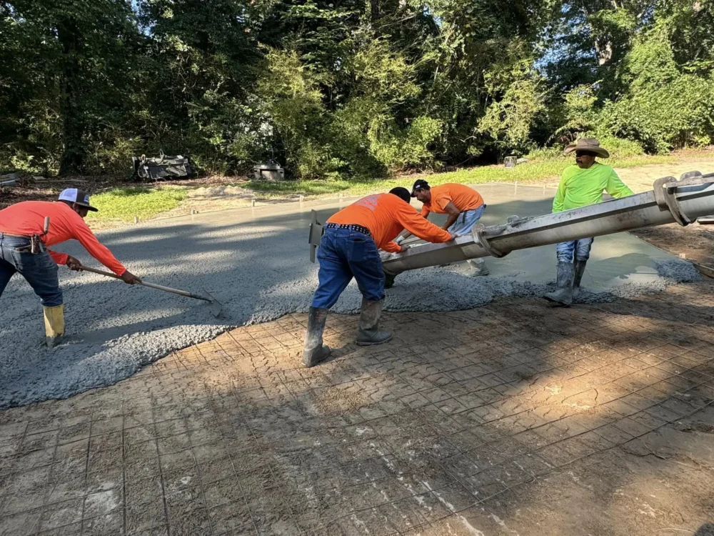 Our Concrete Ninja team is spreading fresh concrete for a new driveway, using wire reinforcement to enhance its strength and durability.