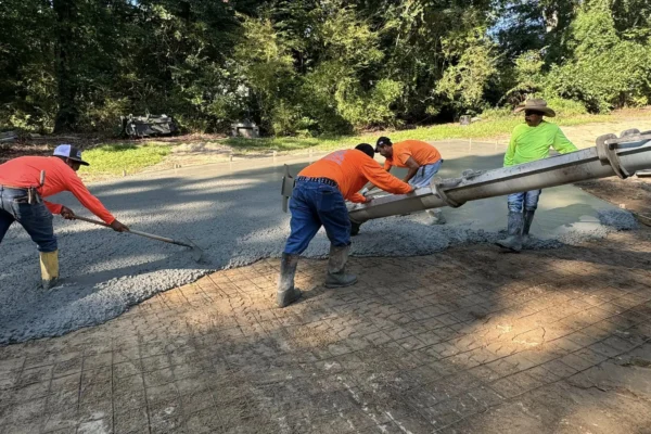 Our Concrete Ninja team is spreading fresh concrete for a new driveway, using wire reinforcement to enhance its strength and durability.